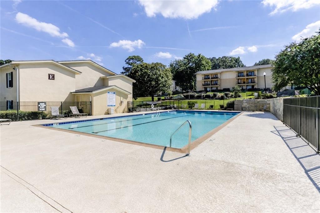 1150 Collier Road Northwest, Unit J11 Atlanta, GA 30318 - Photo 20 of 25 a swimming pool with outdoor seating and yard