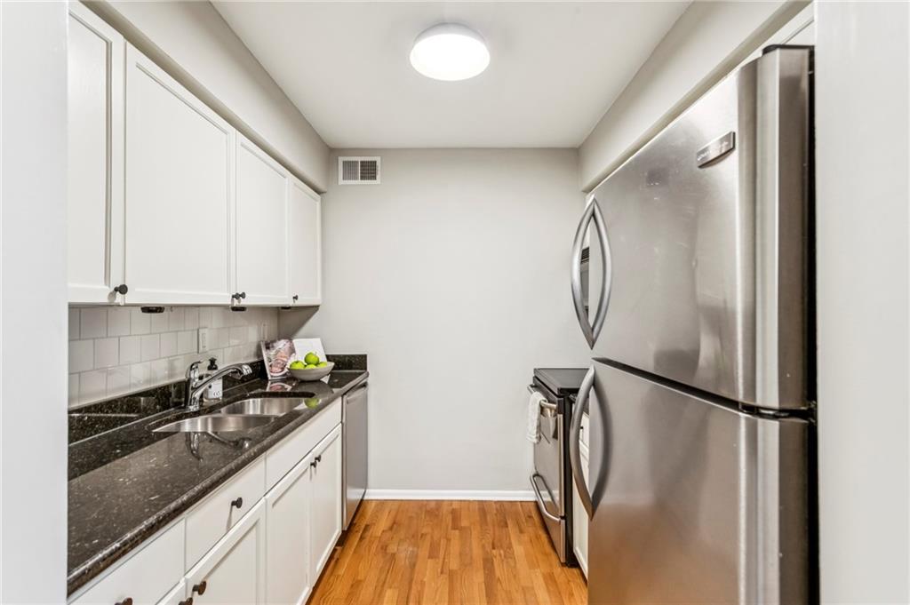 1150 Collier Road Northwest, Unit J11 Atlanta, GA 30318 - Photo 5 of 25 a kitchen with granite countertop a refrigerator and a sink