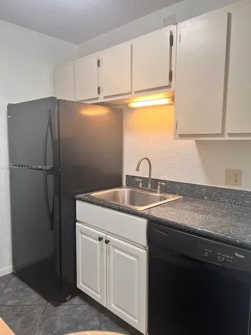 a bathroom with a granite countertop sink a mirror and a shower