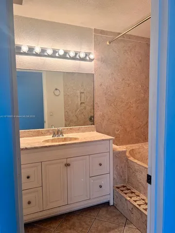 a bathroom with a granite countertop sink and a mirror