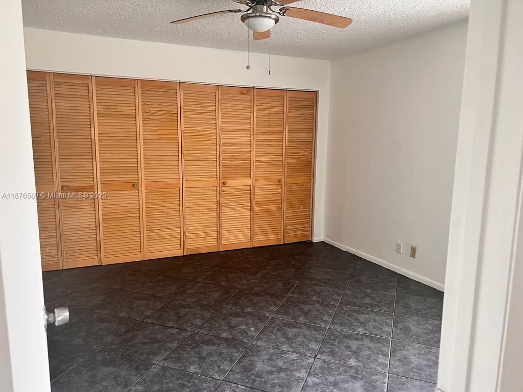 17 Crossings Circle, Unit E Boynton Beach, FL 33435 - Photo 16 of 20 an empty room with a ceiling fan