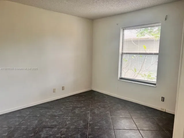 a view of an empty room with brick walls