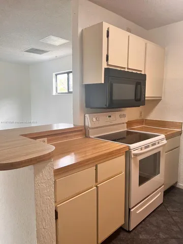a kitchen with appliances a sink and cabinets