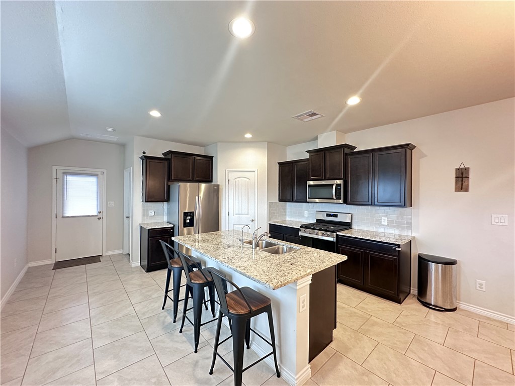 7649 Herd Rider Lane Corpus Christi, TX 78414 - Photo 2 of 18 a kitchen with stainless steel appliances granite countertop a table chairs sink and cabinets