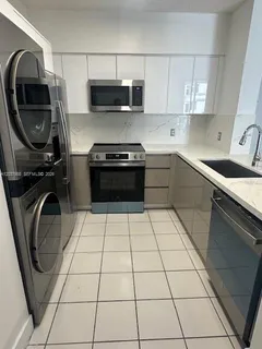 a kitchen with a sink a stove and cabinets