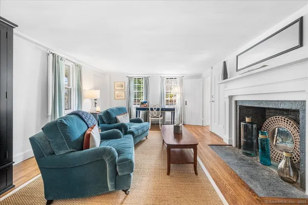 a living room with furniture a fireplace and a floor to ceiling window