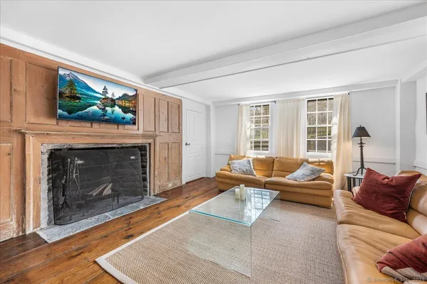a living room with furniture a flat screen tv and a fireplace