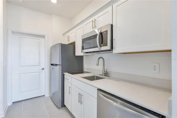 a kitchen with stainless steel appliances white cabinets and a refrigerator