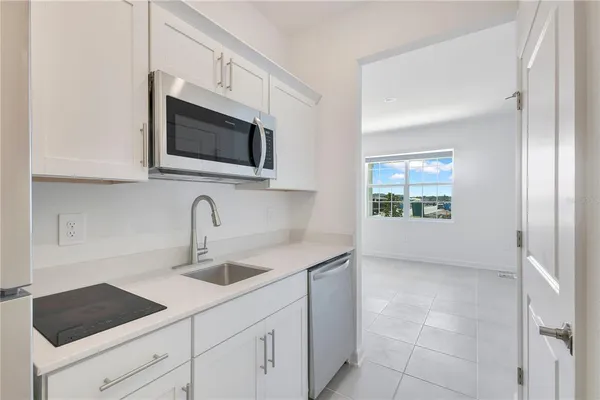 a kitchen with stainless steel appliances granite countertop a sink and a microwave