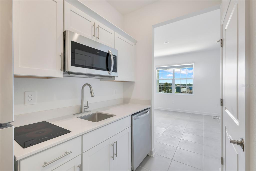3257 Addison Boulevard, Unit B St. Cloud, FL 34771 - Photo 6 of 9 a kitchen with stainless steel appliances granite countertop a sink and a microwave