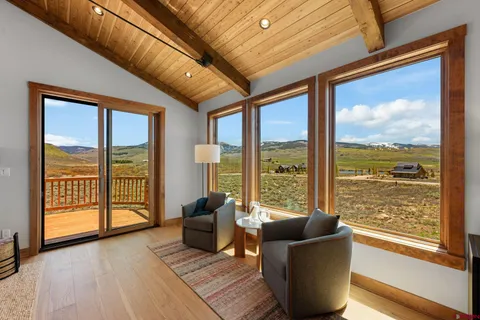 a living room with furniture and floor to ceiling windows