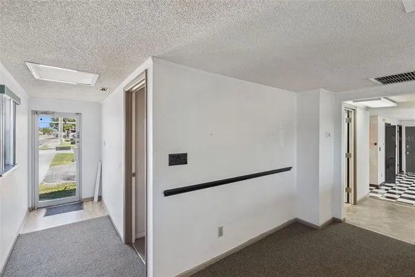 a view of a hallway with wooden floor and a living room