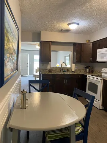 a kitchen with a stove a sink a dining table and chairs