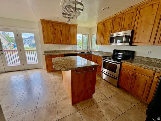 665 West State Road Lehi, UT 84043 - Photo 5 of 30 Kitchen featuring wood cabinetry, an island with a countertop, stainless steel appliances, and a tile floor