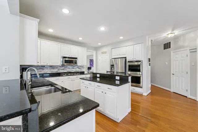 a kitchen with stainless steel appliances granite countertop a sink refrigerator and microwave