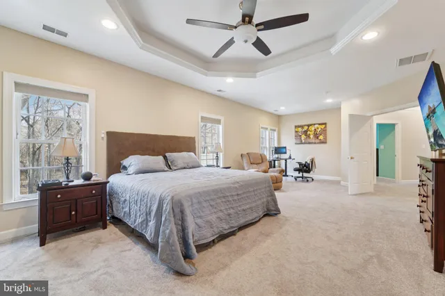 a spacious bedroom with a bed couch and window