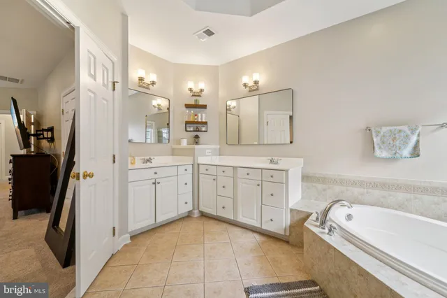 a spacious bathroom with a granite countertop sink a mirror a bathtub and a shower