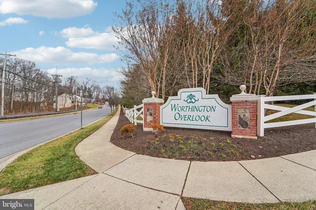 a sign on a sidewalk next to a road