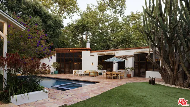 a view of a house with backyard and sitting area