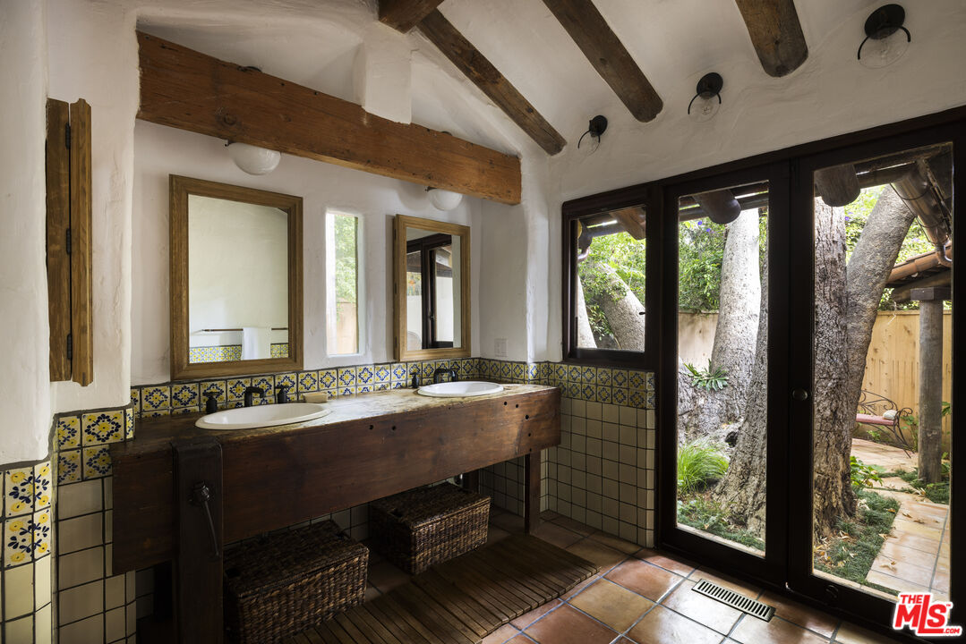 659 East Channel Road Santa Monica, CA 90402 - Photo 8 of 22 a bathroom with a granite countertop sink and a large mirror