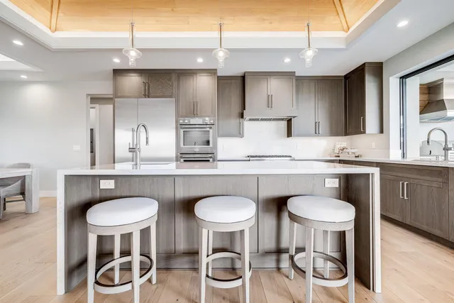 a kitchen with kitchen island granite countertop white cabinets and white appliances