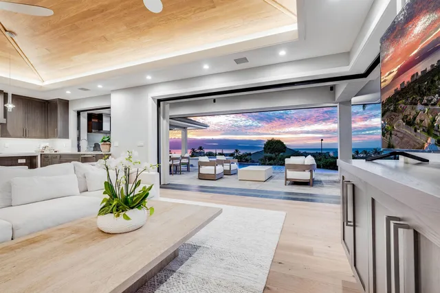 a living room with patio furniture and a chandelier