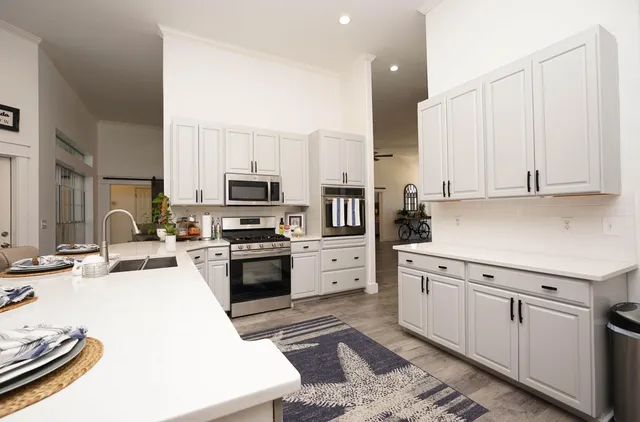 a kitchen with stainless steel appliances kitchen island granite countertop a sink and a stove