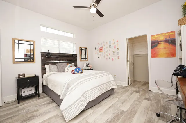 a view of a hallway with wooden floor and a bathroom