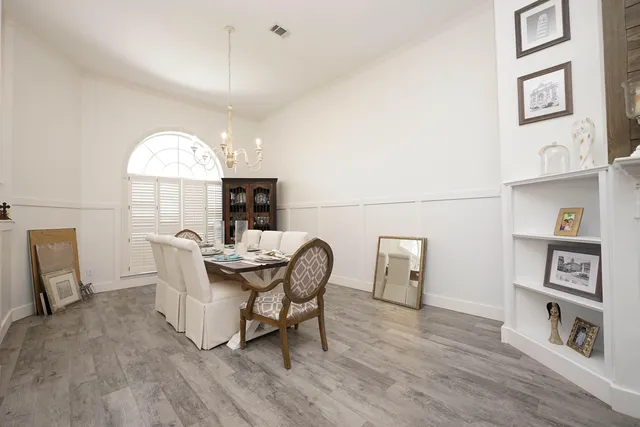 a view of a dining room with furniture a chandelier and wooden floor