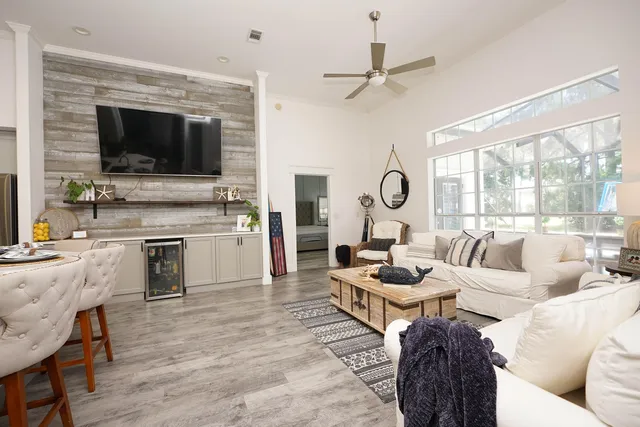 a living room with furniture a large window and a wooden floor