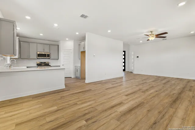 a view of kitchen with cabinets appliances and wooden floor