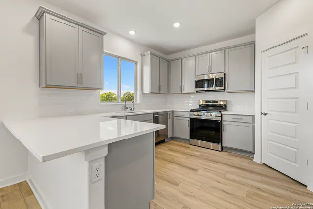 a kitchen with a sink stove top oven and cabinets