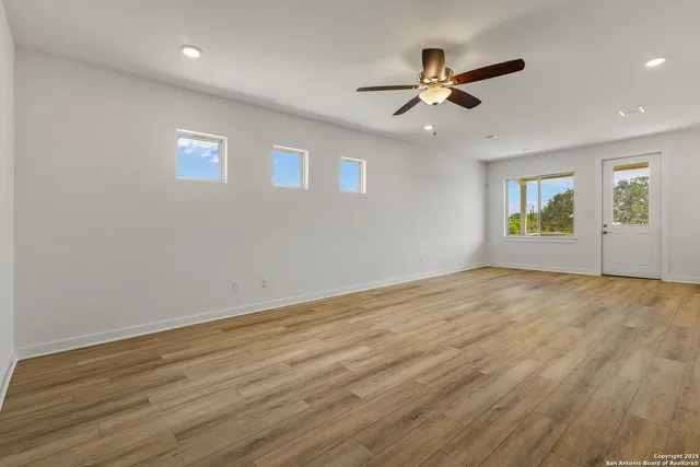 a view of empty room with wooden floor