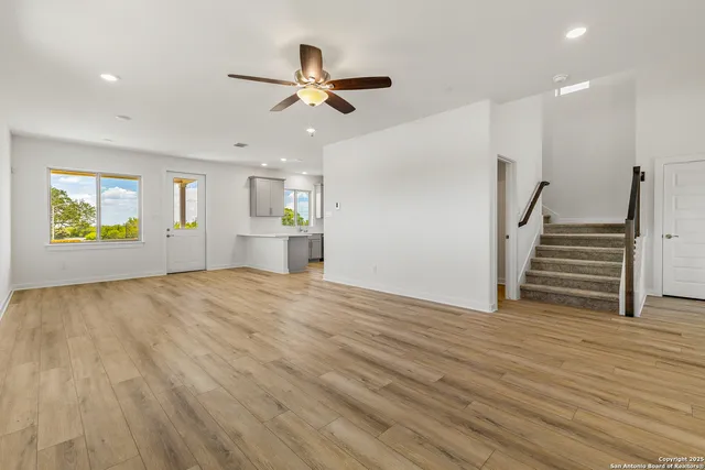 a view of empty room with wooden floor and window