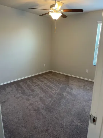 an empty room with a chandelier fan