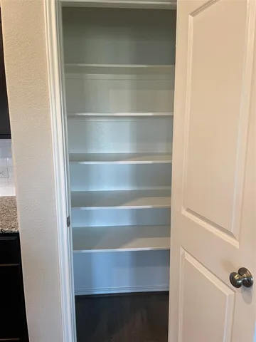 a view of walk in closet with empty racks