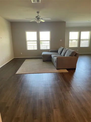 a living room with couches and coffee table with wooden floor