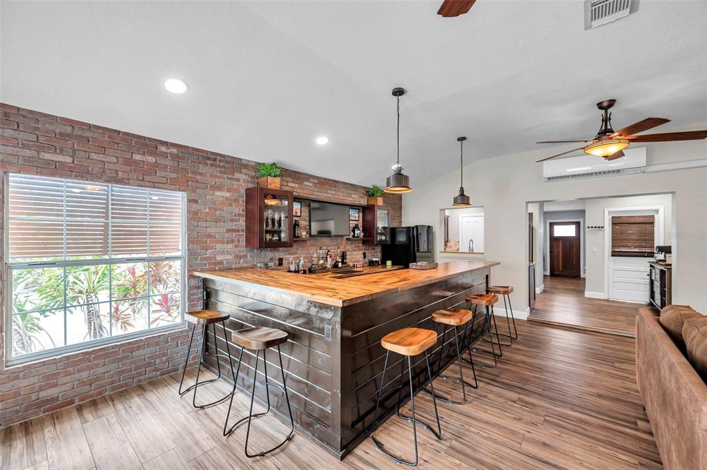 4815 Plantation Drive Tampa, FL 33615 - Photo 13 of 43 a view of a kitchen with kitchen island a stove a refrigerator a dining table and chairs with wooden floor