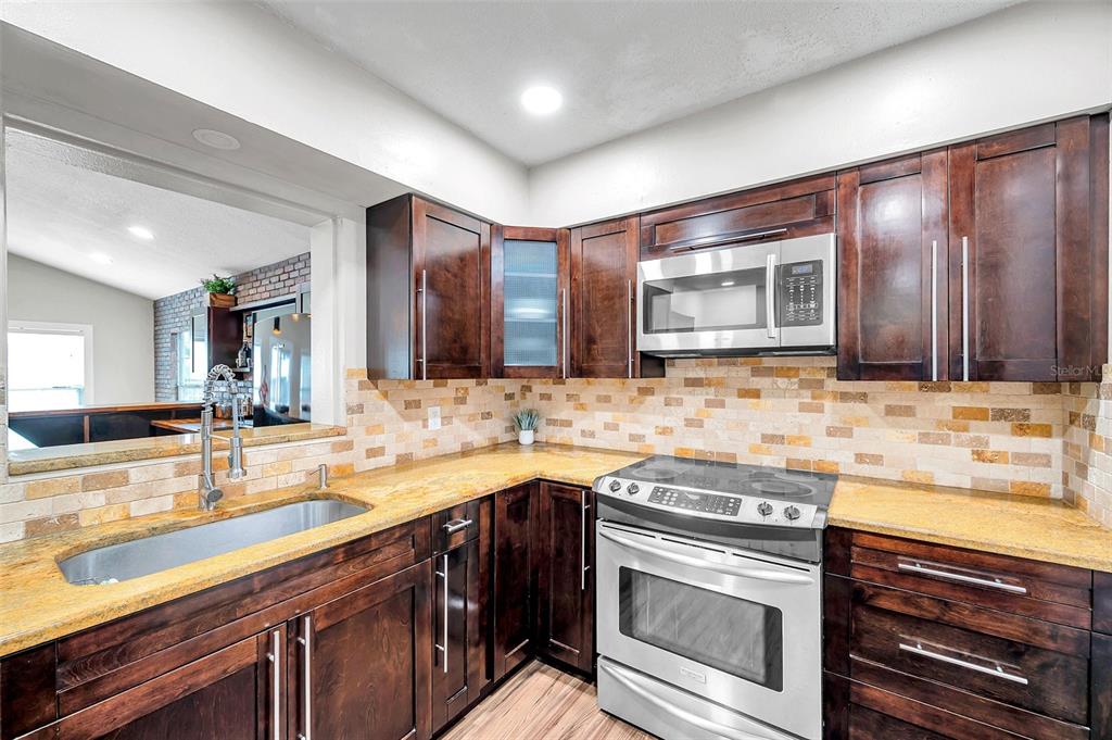 4815 Plantation Drive Tampa, FL 33615 - Photo 5 of 43 a kitchen with stainless steel appliances granite countertop a sink stove and cabinets