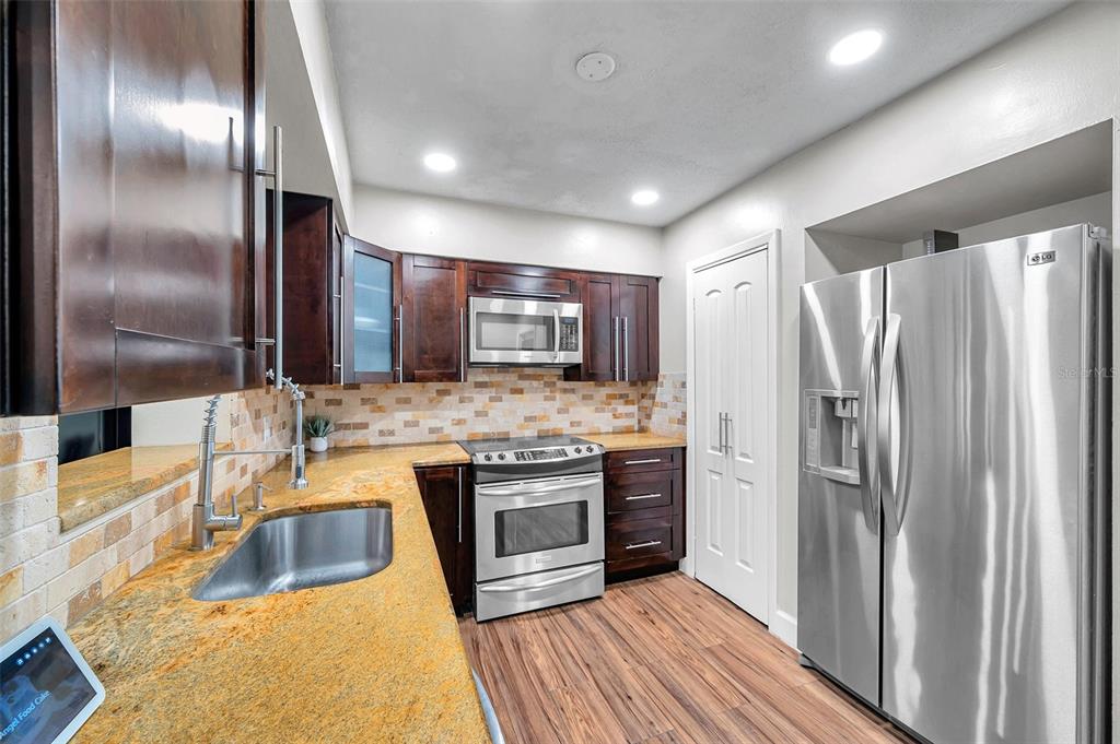 4815 Plantation Drive Tampa, FL 33615 - Photo 6 of 43 a kitchen with kitchen island granite countertop stainless steel appliances a sink stove and refrigerator
