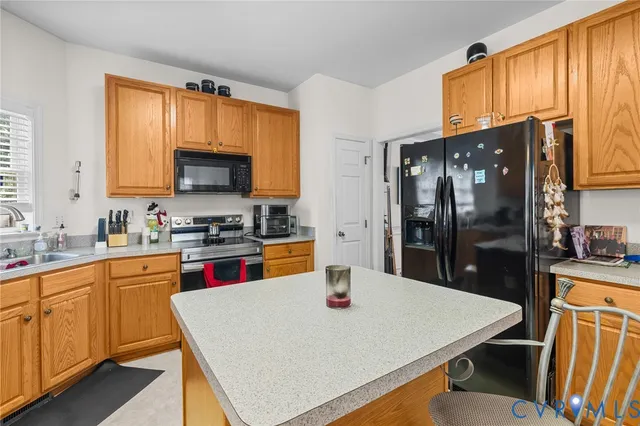 a kitchen with stainless steel appliances a stove refrigerator sink and cabinets