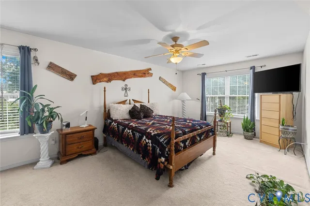a bedroom with a bed and a flat tv screen on dresser