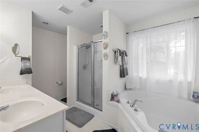 a bathroom with a tub a sink and shower