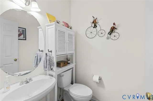 a bathroom with a sink vanity mirror and toilet