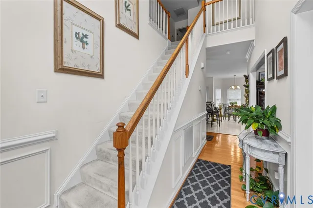a hallway with wooden floor and stairs