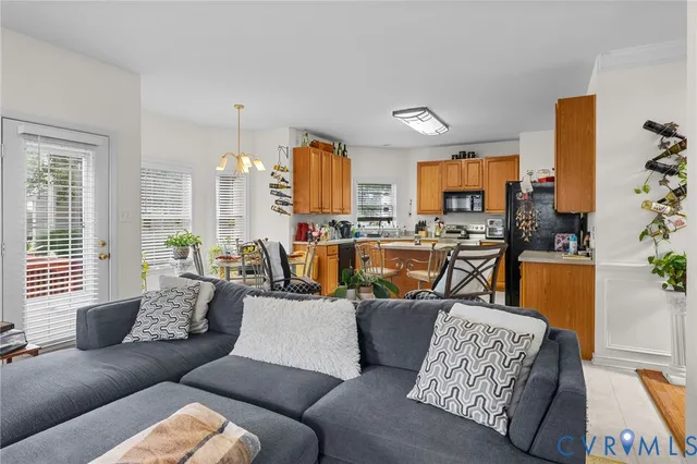 a living room with furniture kitchen view and a large window