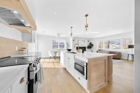 a living room with furniture a fireplace and a large window