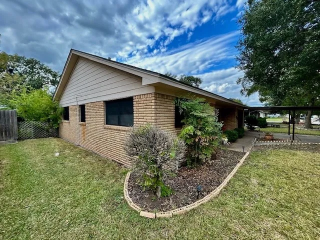 a view of a house with backyard and sitting area