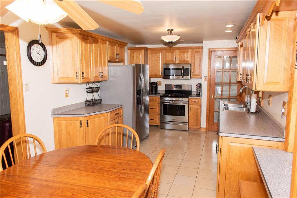 3124 Main Street Aliquippa, PA 15001 - Photo 13 of 30 a kitchen with stainless steel appliances granite countertop a stove a refrigerator a oven a sink a dining table and chairs with wooden floor