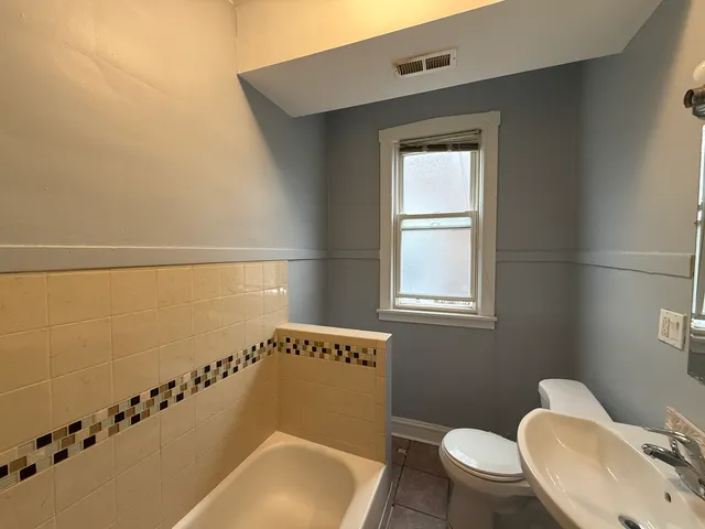 a bathroom with a toilet a sink and mirror